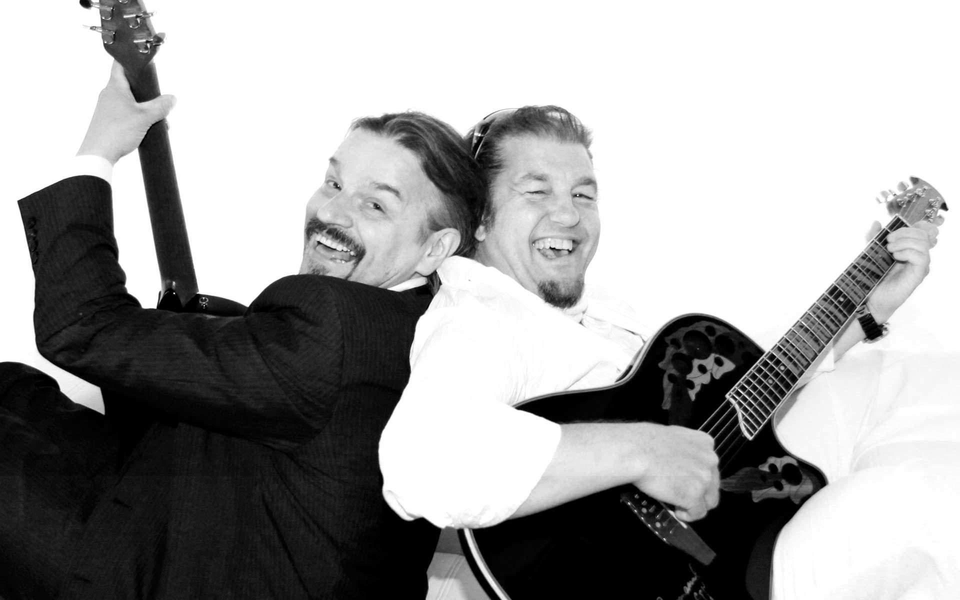 Petar und Bobby von der Liberty Band lachend Rücken an Rücken mit ihren Gitarren